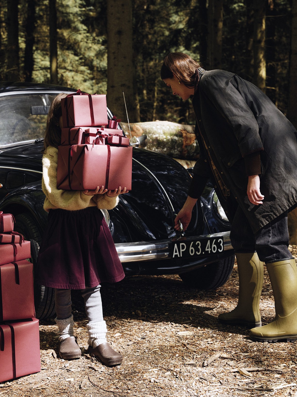 Wrapped Christmas gifts beside a vintage car